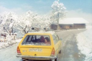 reise durch europa - Gelbes Auto auf einer verschneiten Straße.