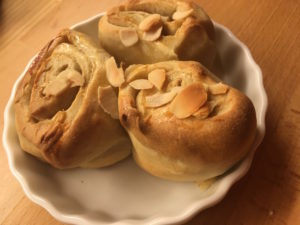 Hefeschnecken - drei frisch gebackene finnische Pulla auf einem Teller.
