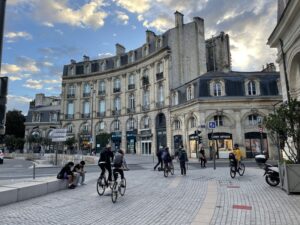 bordeaux sehenswürdigkeiten - Passanten und Radfahrer bei einem Stadtspaziergang in Bordeaux.