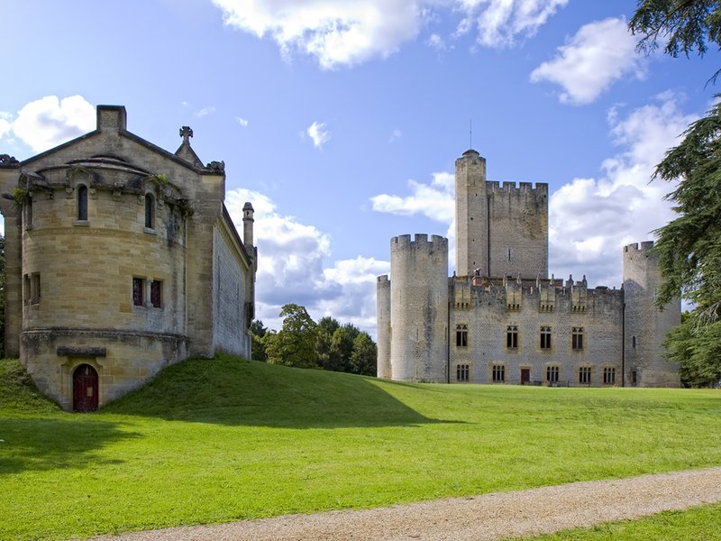 Château de Roquetaillade mit Türmen und Wehrmauern vor grüner Wiese