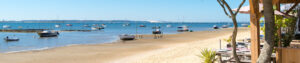 Sandstrand am Bassin d’Arcachon mit ankerten Booten und Blick über das Wasser